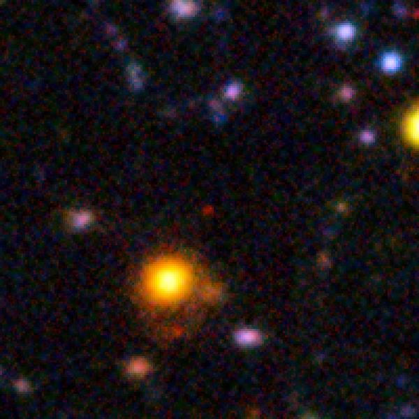 Галактика NTTDF–6345 (красный объект в центре), которую мы видим такой, какой она была через 840 млн лет после Большого взрыва (иллюстрация ESO / L. Pentericci).